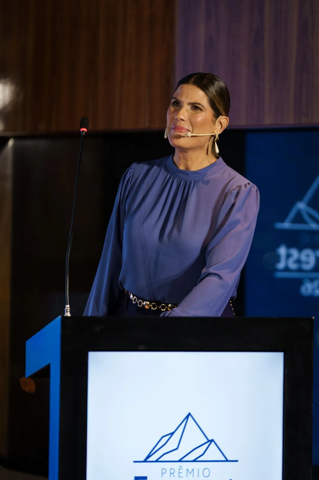 Adriana Reid apresentando no palco, microfone de lapela